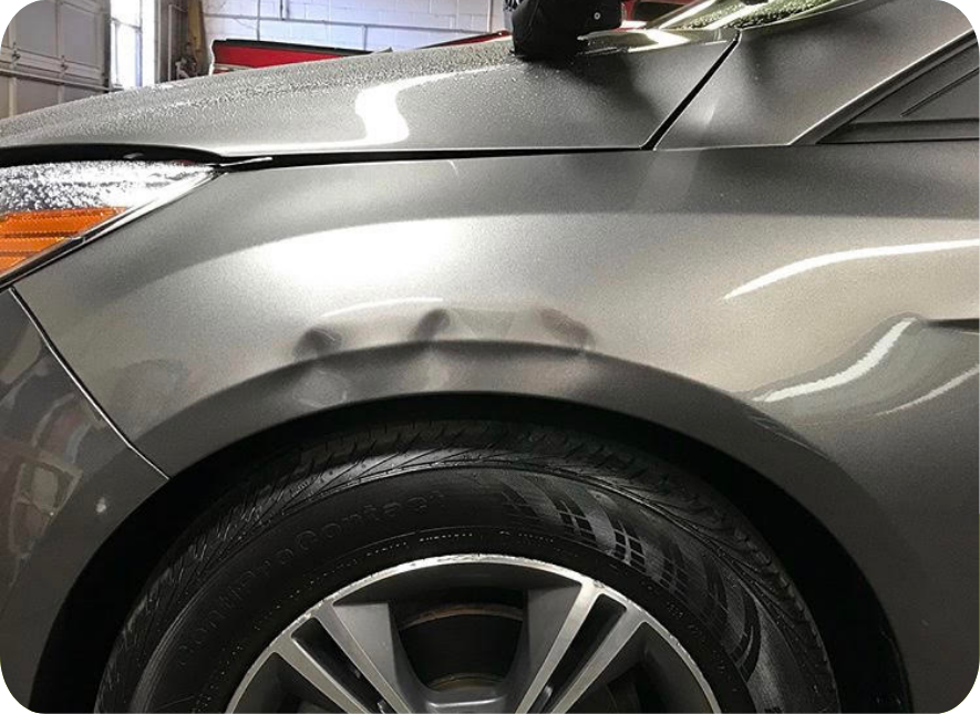 Image of an SUV with a dent or ding above the wheel well